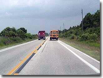 Dump truck blows past schoolbus.